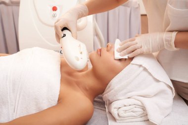 Eldivenli makyajcısı peçete elektrik malzemesi ile güzellik işlemi sırasında istemci gözünü tutarak