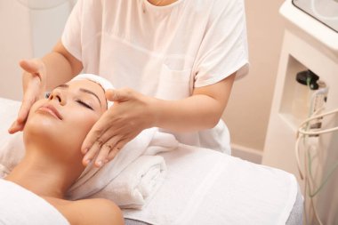 Cilt Cilt Bakımı işlemden sonra sakinleşmeye istemci yanakları dokunmadan genç güzellik uzmanı