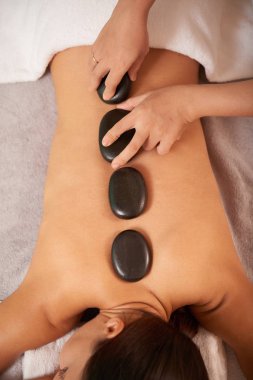 El yordamı önce spa taş koyarak makyajcısı ve rahat istemciyi geri genel bakış