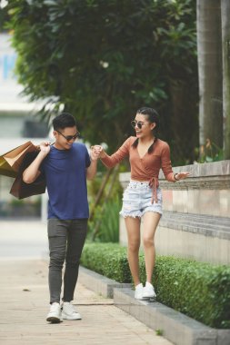 Neşeli Vietnamca çift gün açık havada alışveriş torbaları ile harcama gülüyor 