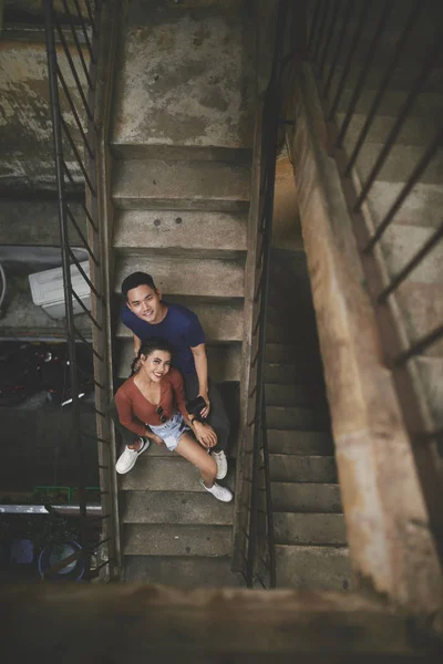 Sonriendo Joven Pareja Vietnamita Sentado Las Escaleras Mirando Cámara Vista —  Fotos de Stock