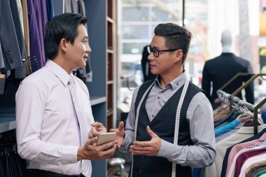 Erkek giyim alışveriş yardımcısı ve istemci tartışıyor