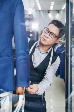 Vietnamca satıcı manken takım elbise ile dükkan pencerede belirli bir konuma geçirme