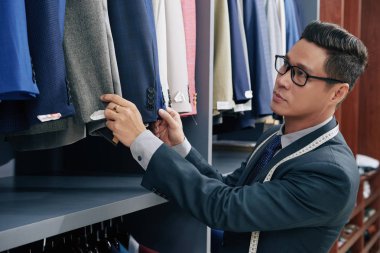 Takım elbise ve ceket dükkanında kontrol satıcısı