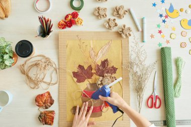 Çiçek resim dekorasyon süre sıcak tutkal tabancası kullanan kadın görünümünü hemen üstüne 