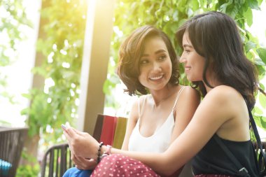 Neşeli çekici genç Asyalı kadınlar ile smartphone