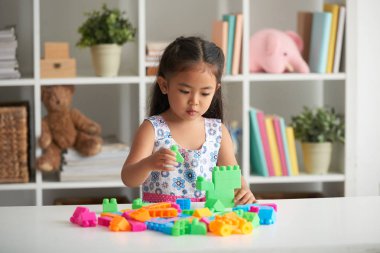 Plastik küpleri ile oynarken küçük Asyalı kız