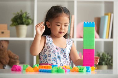 Küçük kız parlak plastik küpleri ile bina