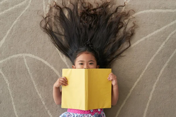 Pequeña Chica Asiática Tumbada Suelo Con Libro Abierto —  Fotos de Stock