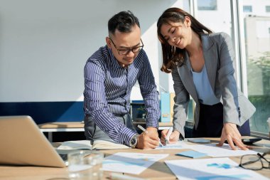 Masa başında çalışma istatistikleri tartışmak ve planlama Vietnamca iş arkadaşları 