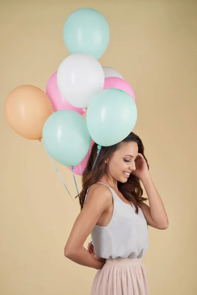 微笑有吸引力的年轻妇女在演播室拿着堆气球 — 图库照片