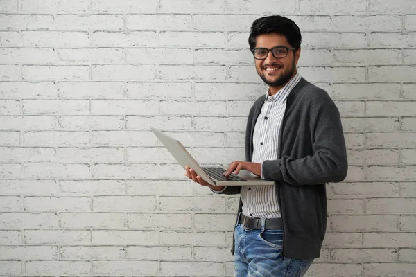 Portrait Cheerful Indian Programmer Man Laptop Standing White Brick Wall — Stok Foto