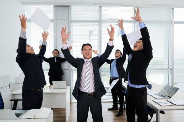 Grup neşeli Asya işadamlarından belgeleri hava atma