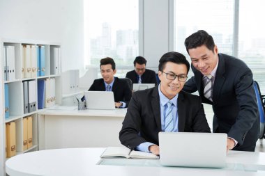 Asya yöneticileri office içinde laptop bakarak
