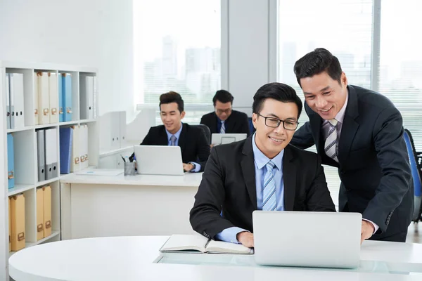 亚洲经理在办公室看笔记本电脑 — 图库照片