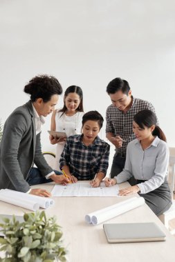Masada oturan ve bir proje üzerinde çalışırken iş takım