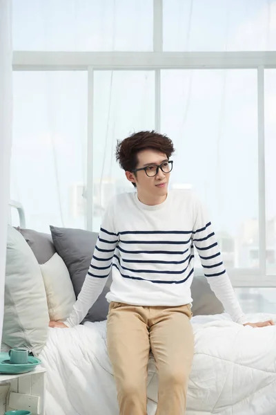 Schöner Junger Asiatischer Mann Sitzt Auf Seinem Bett — Stockfoto