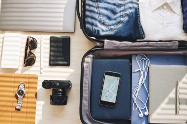 Smartphone ile bavul ve diğer gadget'lar masaya harita görüntüsü
