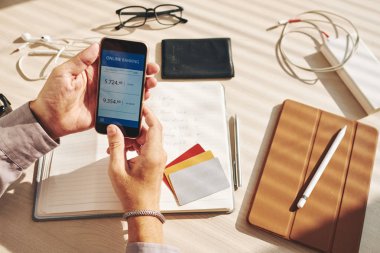 Adam hesap bir online banka, onun smartphone kontrol