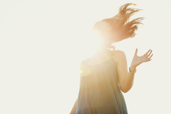 Young joyful woman dancing in sunlight, freedom 