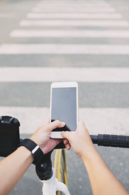 Yoldan geçerken mobil app kullanarak bisiklet binici