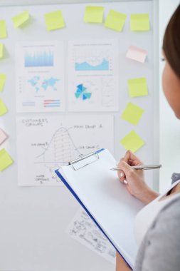 İş ilerleme üzerinde sonuç çıkarmak için çeşitli grafik ve diyagramlar ile tahta at arıyorum iş kadını