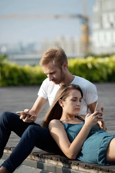 Cuplu Tânăr Folosind Smartphone Uri Timp Relaxează Împreună Aer Liber — Fotografie, imagine de stoc