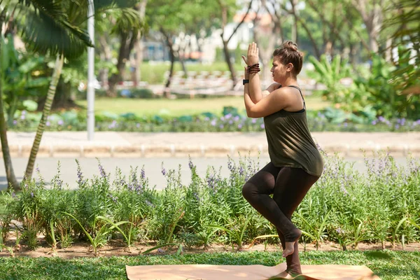 绿色公共公园练习瑜伽的妇女 — 图库照片
