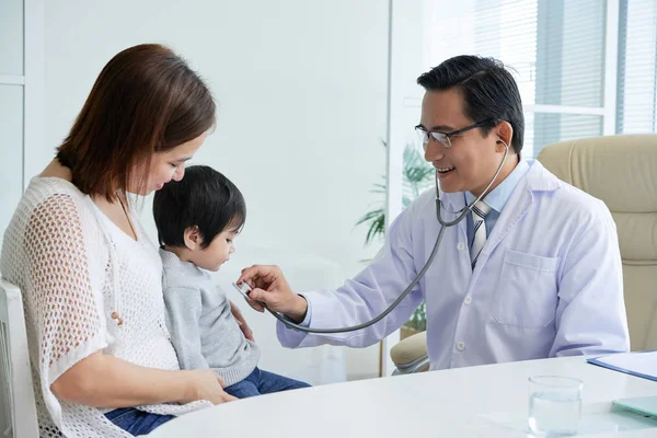 Médico Mirando Lindo Pequeño Paciente Mientras Examina Con Estetoscopio — Foto de Stock