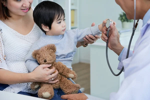 Curioso Asiático Menino Sentado Voltas Mãe Examinando Estetoscópio Mão Médico — Fotografia de Stock