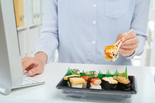 オフィス ワーカーのランチに寿司や刺身を食べることの画像をトリミング — ストック写真