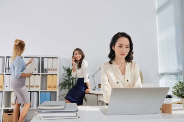 Office, laptop meslektaşları arka planda çalışan çok Çin iş kadını 