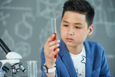 Asyalı öğrenci içeriğini test tüpü kimya sınıfında okuyan