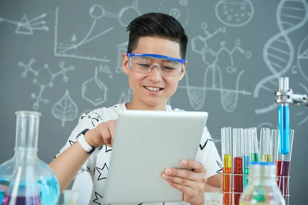 Cheerful Asian Pupil Wearing Protective Goggles Using Digital Tablet Chemistry — Stock Photo, Image