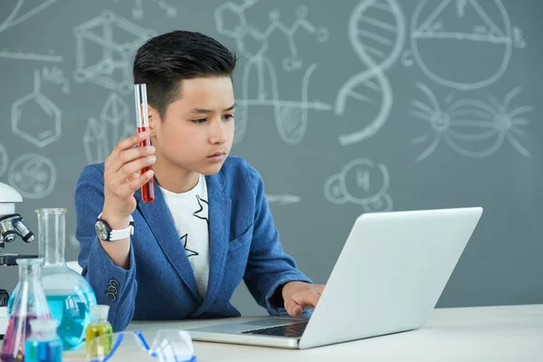 Asyalı Çocuk Kimya Sınıf Modern Dizüstü Bilgisayar Araştırma Projesi Önünde — Stok fotoğraf