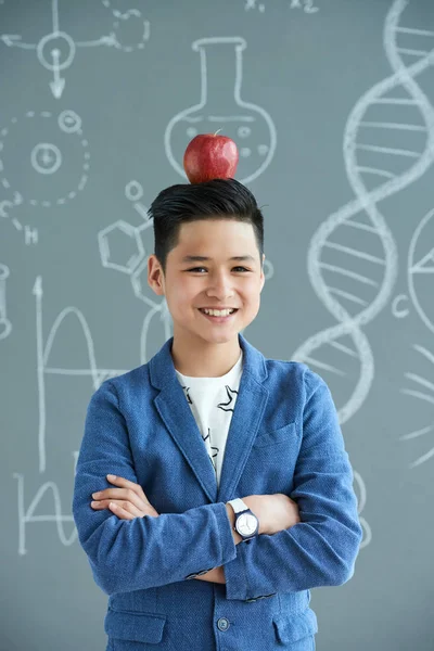 Sorridente Pupilla Asiatica Con Mela Rossa Matura Sulla Testa — Foto Stock