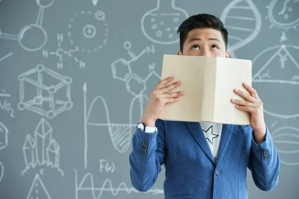 Asian Pupil Covering His Face Textbook Looking Upwards While Standing — Stock Photo, Image