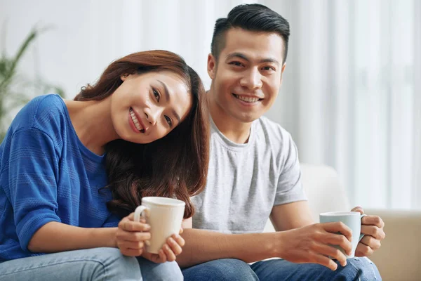 コンテンツのアジア男と女のコーヒー カップを押しながらカメラで幸せそうに笑って — ストック写真