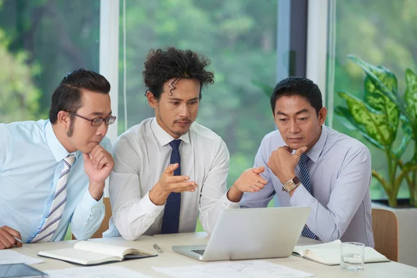 Ernstige Aziatische Zakenmensen Lezen Van Belangrijke Informatie Laptop Scherm — Stockfoto