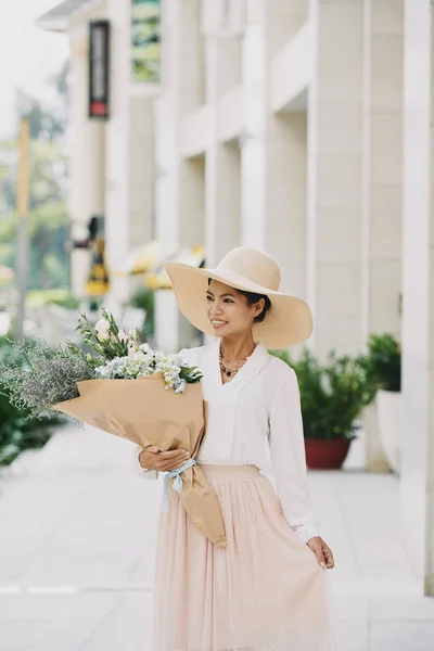 迷人的年轻女子戴着一束大花束的夏天帽子 — 图库照片