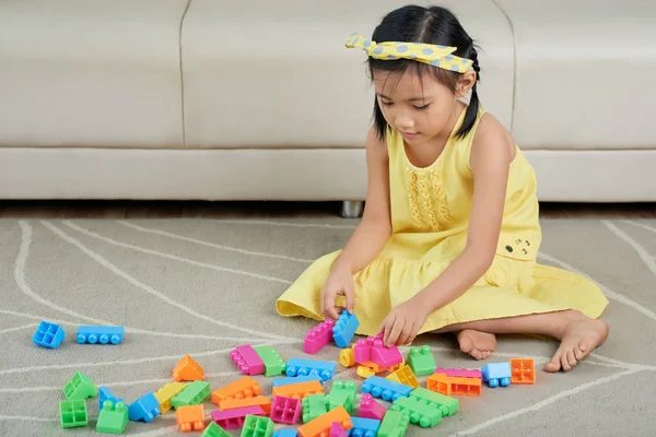 小亚洲女孩在地板上玩玩具 — 图库照片