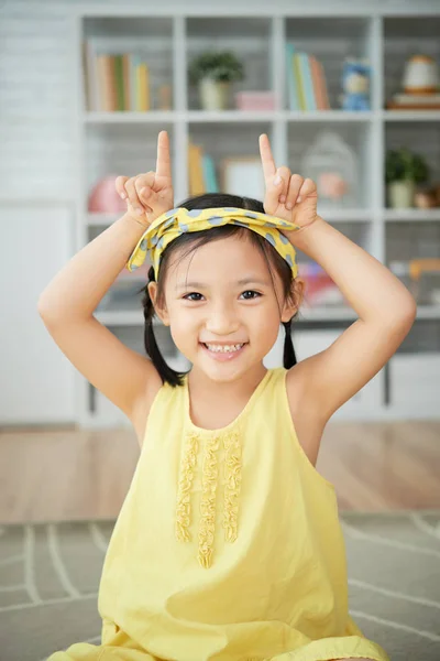 微笑的小女孩的肖像用她的手做牛角 — 图库照片