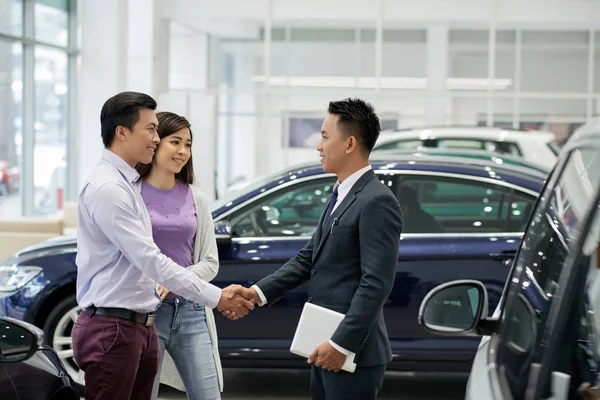 Young Asian Salesman Greeting Couple Car Dealership — Stock Photo, Image