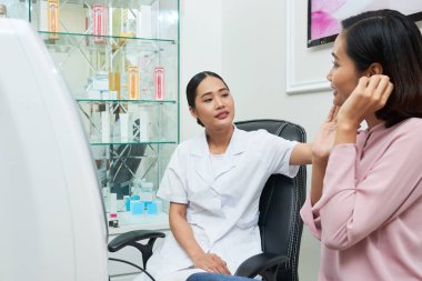 Masada oturan ve cilt istemci türünü belirleme konusunda son derece profesyonel güzellik uzmanı 