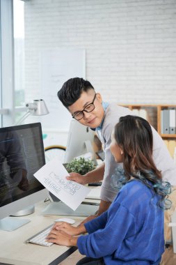 Genç iş adamları iş tartışırken birlikte ofis masası bilgisayar ile planı. 