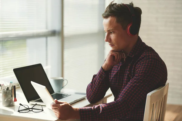 Hombre Pensativo Auriculares Inalámbricos Viendo Algo Computadora Tableta —  Fotos de Stock