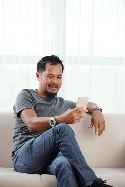 Hombre Vietnamita Guapo Con Teléfono Inteligente Descansando Sofá — Foto de Stock