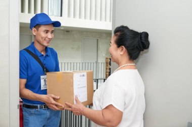 Yaşlı kadın için büyük bir kutu veriyor neşeli Asya kurye