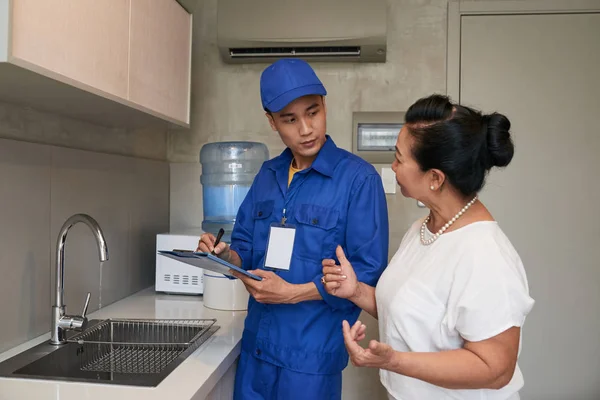 Mature Vietnamese Woman Talking Plumber Her Kitchen — Stock Photo, Image