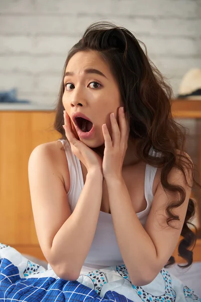 Überrascht Asiatische Frau Mit Geöffnetem Mund Sitzt Auf Gemütlichen Bett — Stockfoto